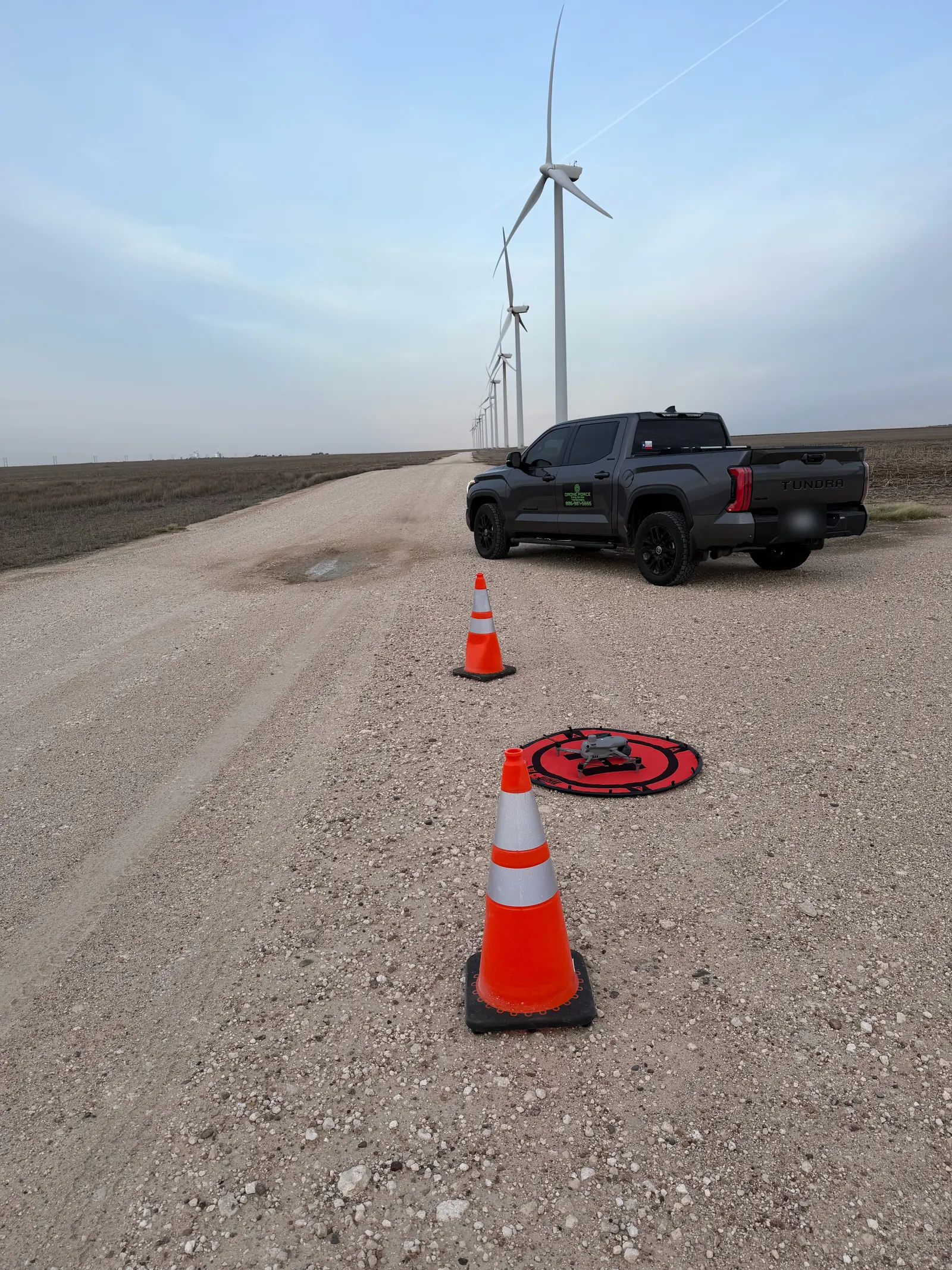 Drone Force truck, cones and drone landing pad set up on a wind farm road