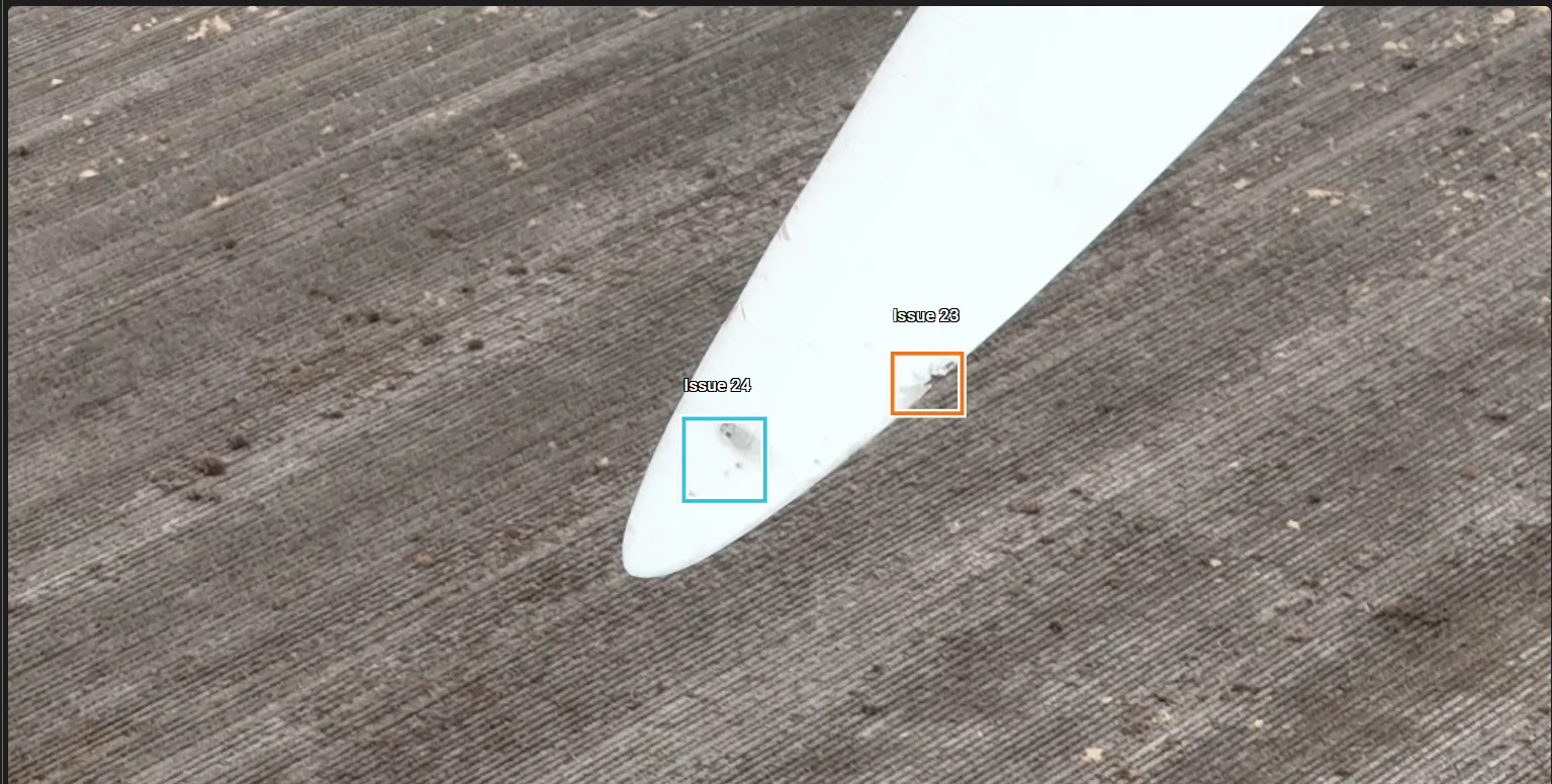 Wind blade tip over plowed ground with two small defects marked